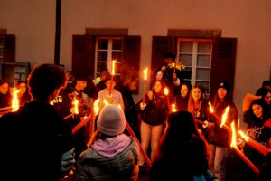 vor dem Rathaus Maulbronn steht eine singende Schülergruppe aus Italien mit Fackeln